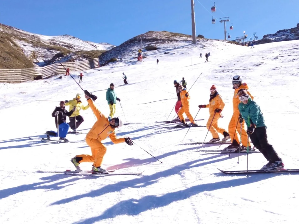 Alumnos y profesores practicando esquí en una pista de Sierra Nevada